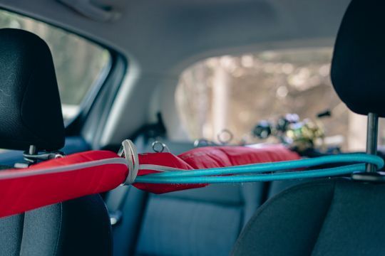 Fishing pole holder that uses car window to transport fishing