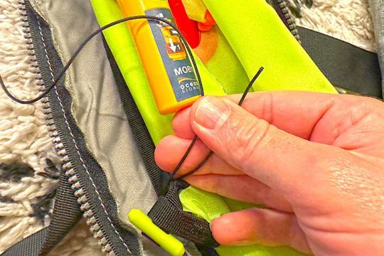Trouvez une boucle d'attache sur le gilet et passez la corde