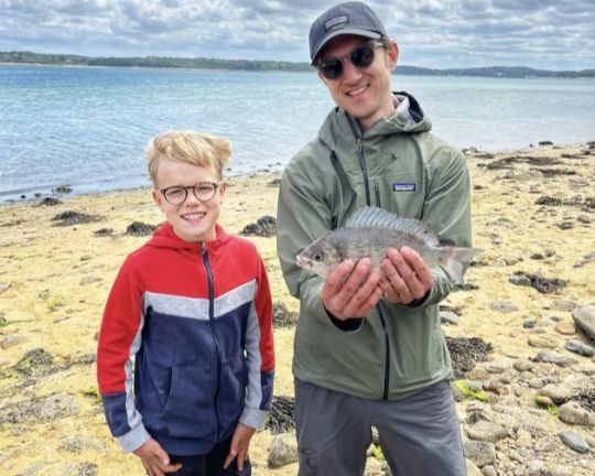 Deux stagiaires heureux d'avoir attrapé une dorade grise.